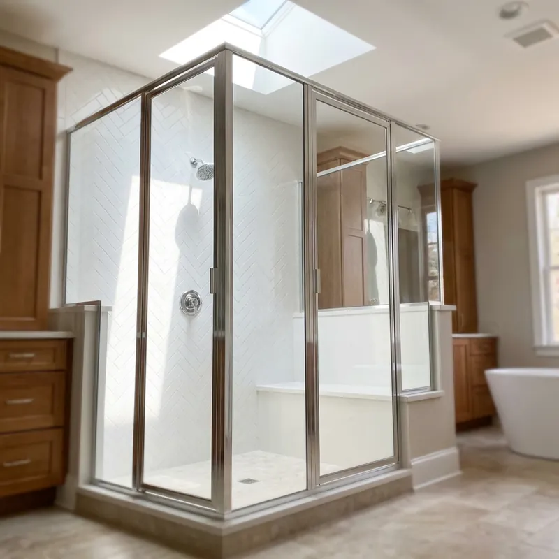 Recent semi-frameless shower door installation — three-panel walk-in over herringbone tile with chrome hardware